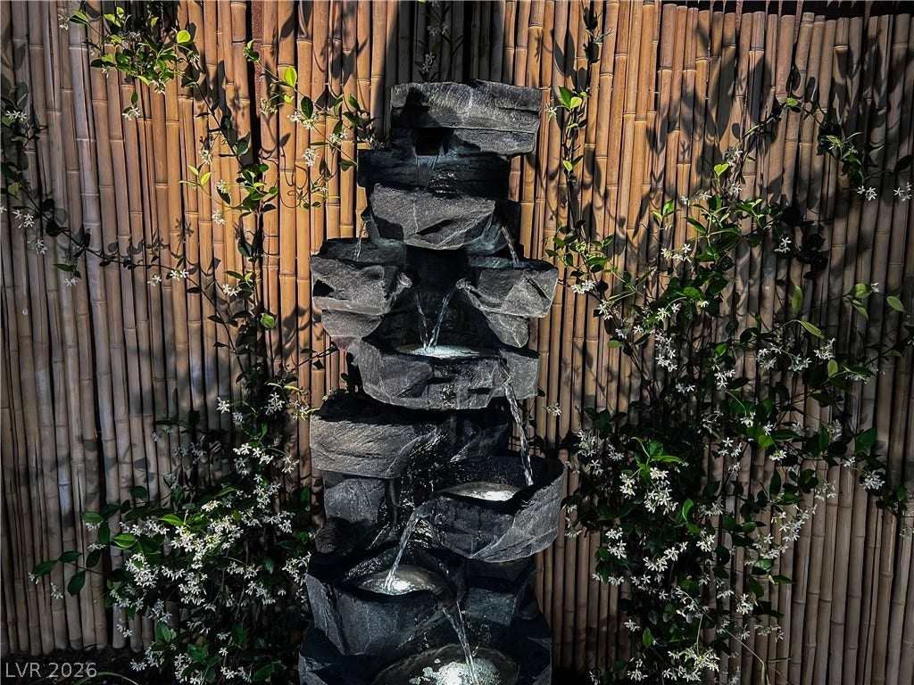 6007 Sonoma Station Avenue, Las Vegas, NV 89139 An elegant stone-look water feature bubbles peacefully against a natural bamboo privacy screen.
