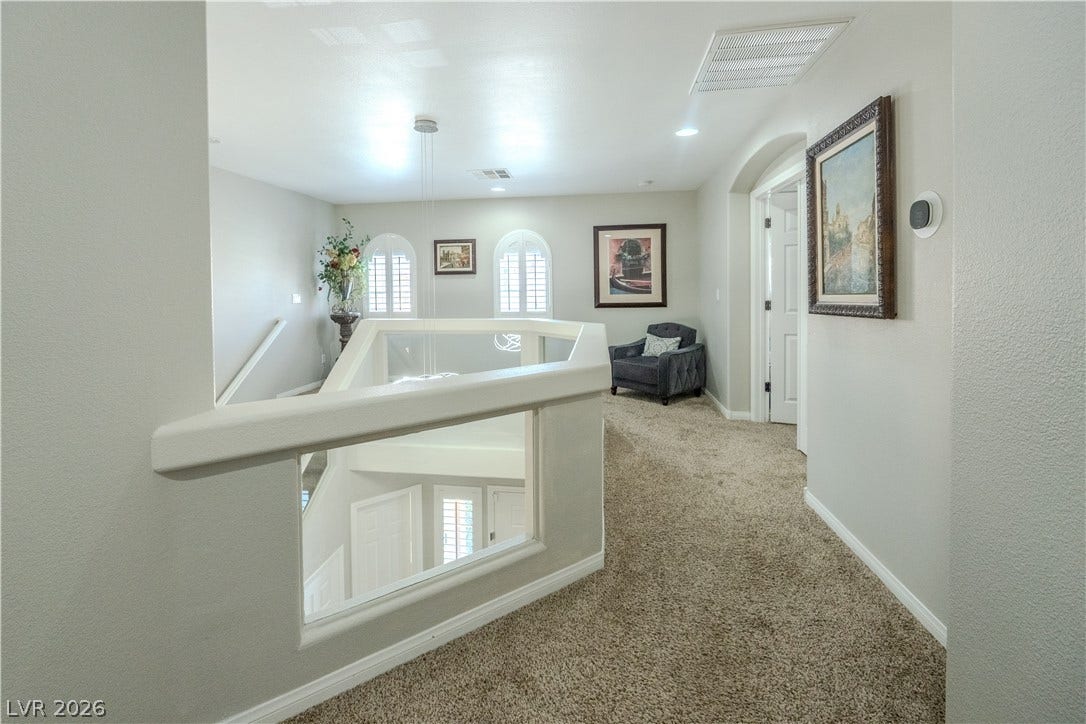 6007 Sonoma Station Avenue, Las Vegas, NV 89139 A spacious upper hallway overlook features neutral plush carpeting and arched window openings.