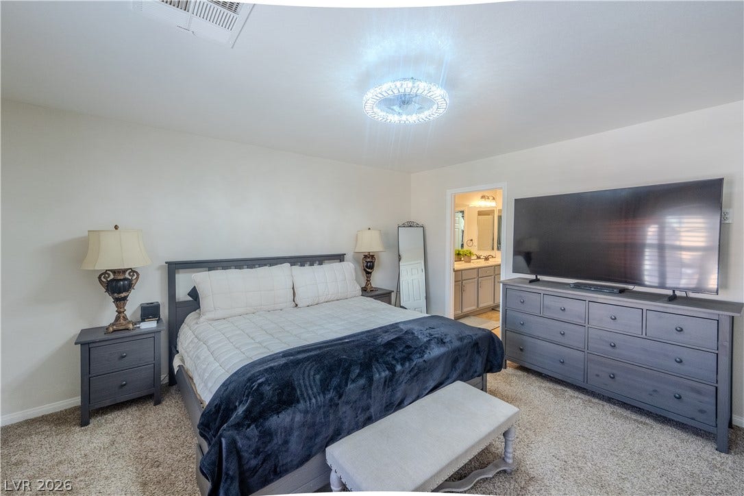 6007 Sonoma Station Avenue, Las Vegas, NV 89139 Plush carpet and a modern ceiling light fixture define this comfortable bedroom space.