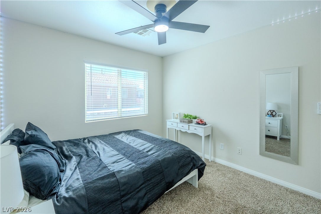 6007 Sonoma Station Avenue, Las Vegas, NV 89139 A spacious bedroom features soft neutral walls, classic carpeting, and ample natural light.