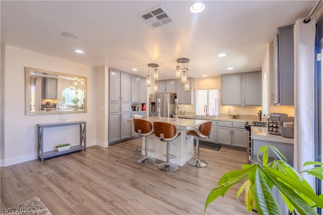 6007 Sonoma Station Avenue, Las Vegas, NV 89139 Gleaming wood floors and customized cabinetry define this modern kitchen spaces.