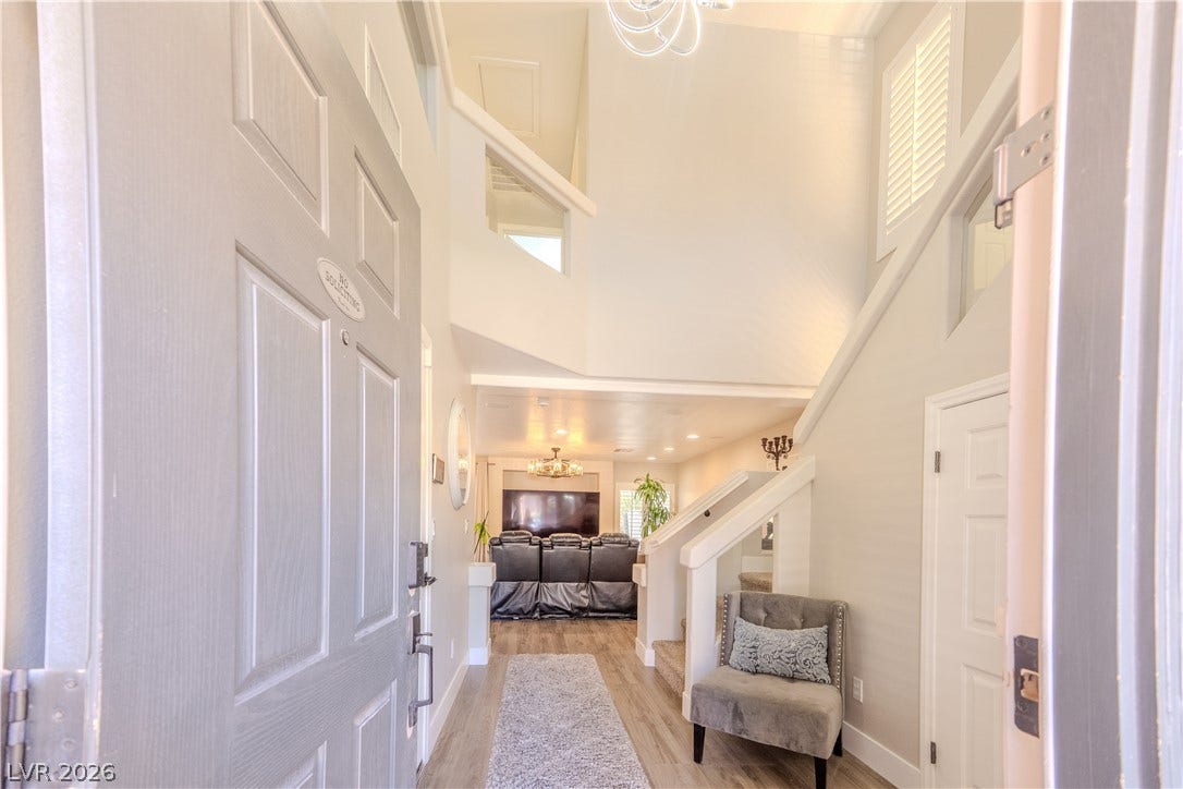 6007 Sonoma Station Avenue, Las Vegas, NV 89139 A soaring ceiling and wood-style flooring welcome visitors into this light-filled entry hallway.