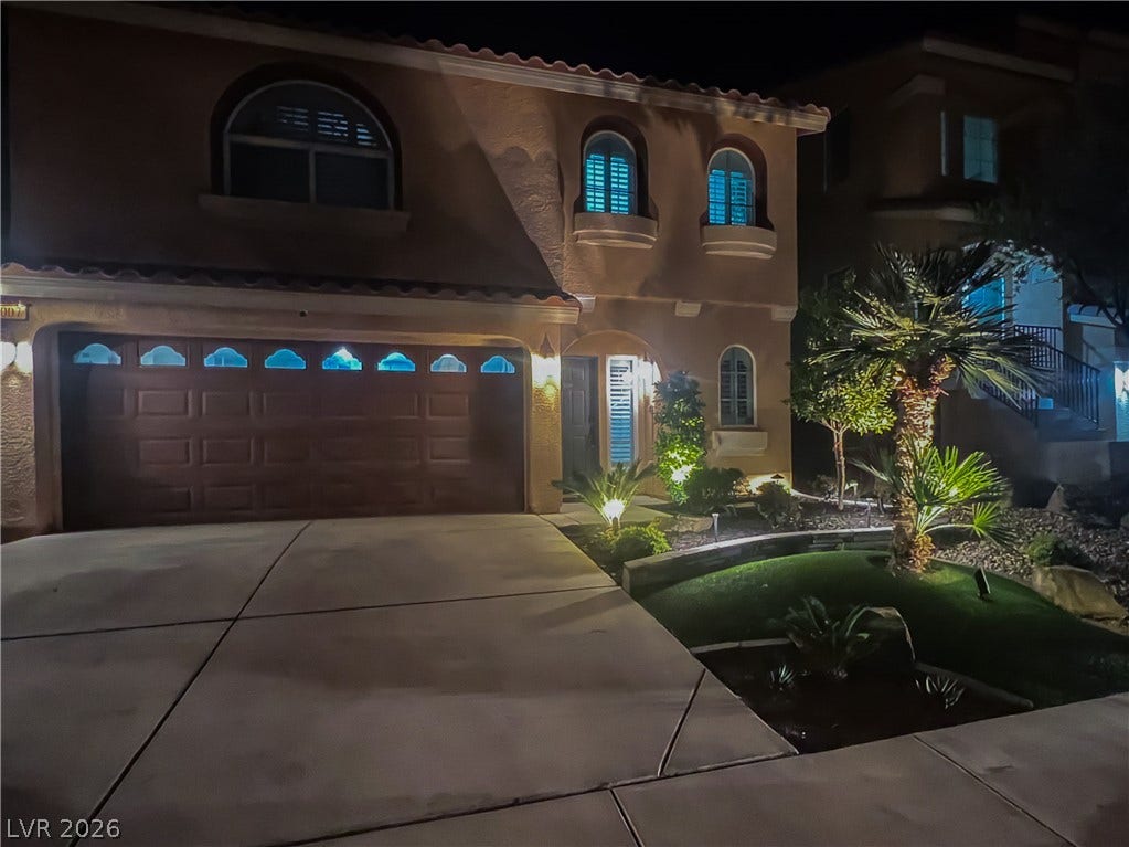 6007 Sonoma Station Avenue, Las Vegas, NV 89139 Dramatic nighttime exterior lighting accentuates the elegant Mediterranean-style facade and neatly manicured desert landscaping.