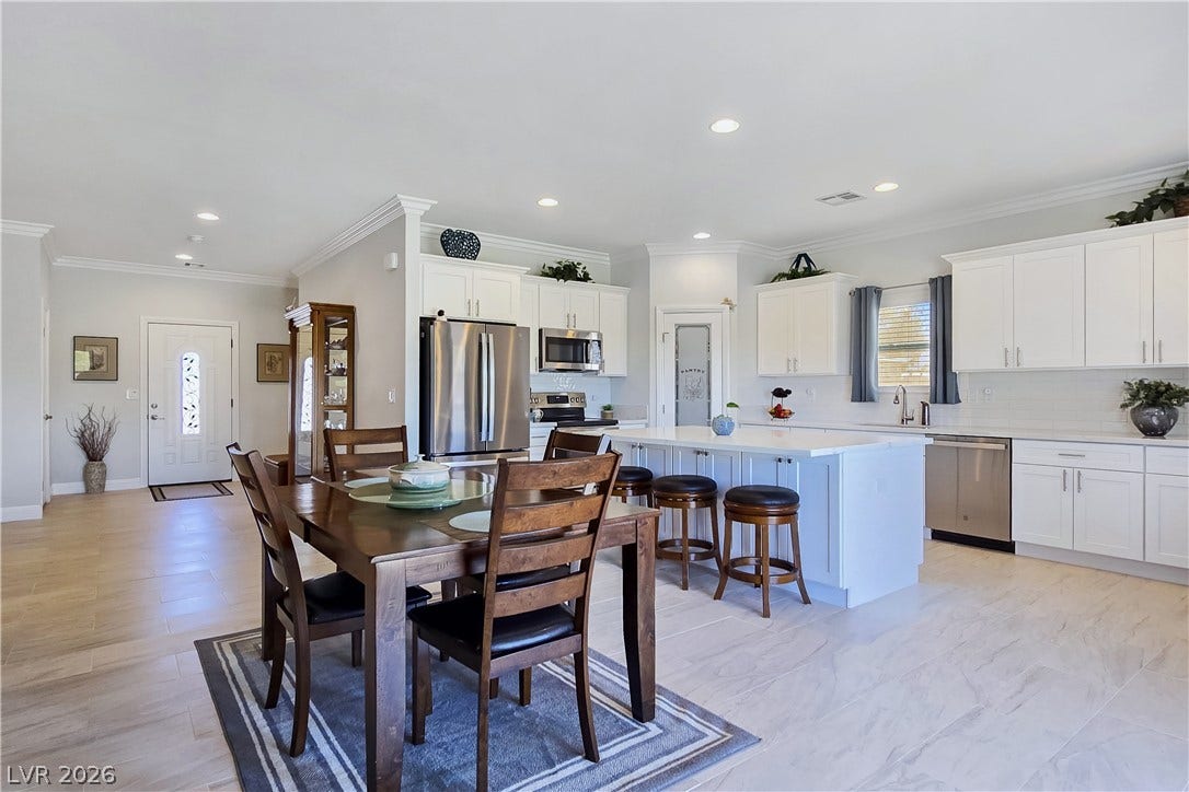 5471 Lincolnwood Court, Pahrump, NV 89061 Gleaming tile floors and crown molding elevate this open-concept kitchen and dining area.