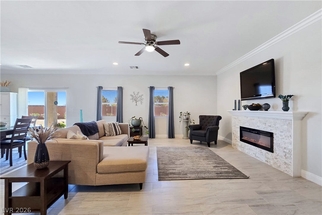 5471 Lincolnwood Court, Pahrump, NV 89061 Crown molding and a modern fireplace elevate the open living space.