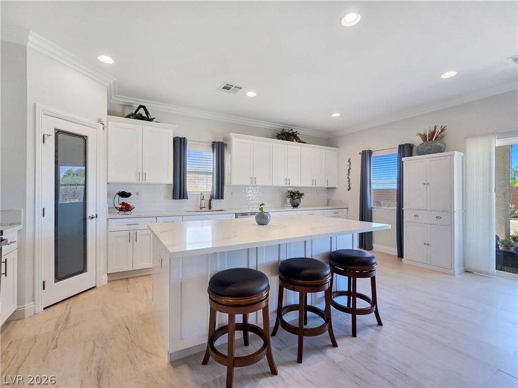 5471 Lincolnwood Court, Pahrump, NV 89061 A spacious kitchen highlights stone counters, a central island, and modern recessed lighting.