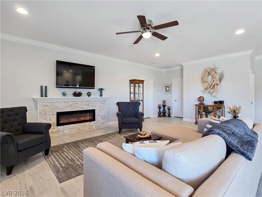 5471 Lincolnwood Court, Pahrump, NV 89061 An elegant stone fireplace anchors this open living space highlighted by crown molding.