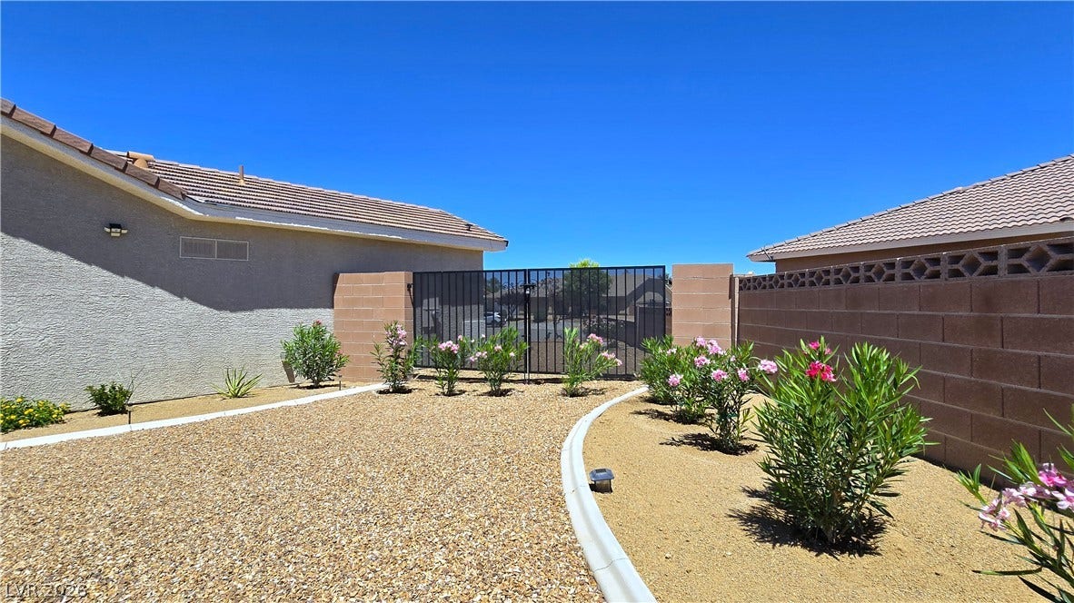 5471 Lincolnwood Court, Pahrump, NV 89061 Desert landscaping and block wall fencing frame the secure gated entry of this residence.