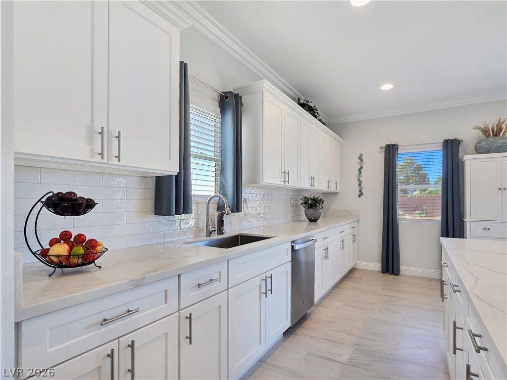 5471 Lincolnwood Court, Pahrump, NV 89061 Crisp crown molding accents this modern culinary space featuring stone counters and tile flooring.