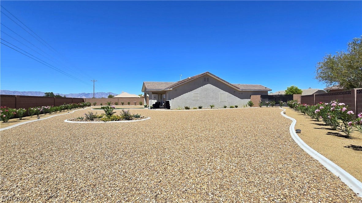 5471 Lincolnwood Court, Pahrump, NV 89061 Low-maintenance desert landscaping surrounds this home under a clear blue sky.