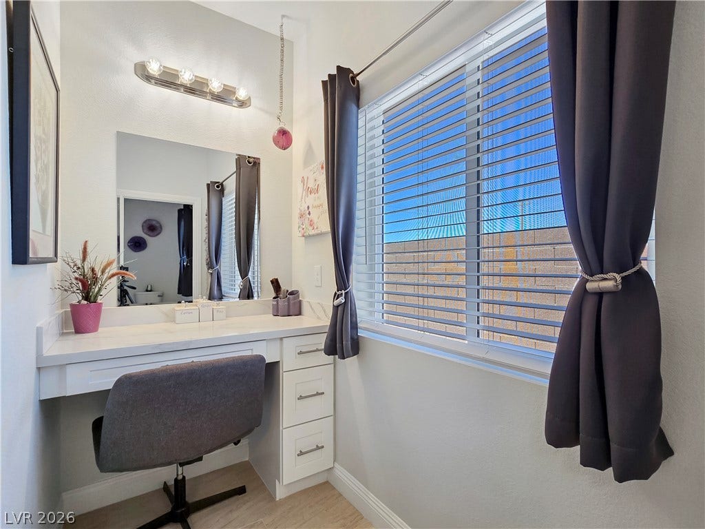 5471 Lincolnwood Court, Pahrump, NV 89061 A dedicated dressing table features stone counters and abundant natural light from a large window.