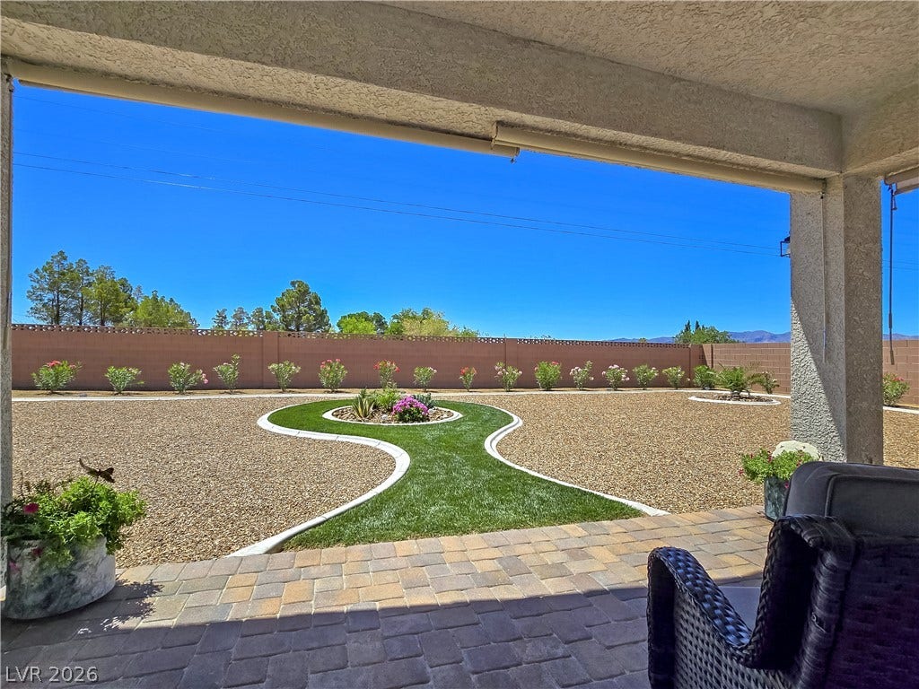 5471 Lincolnwood Court, Pahrump, NV 89061 A covered paver patio overlooks a meticulously landscaped desert backyard with a privacy wall.