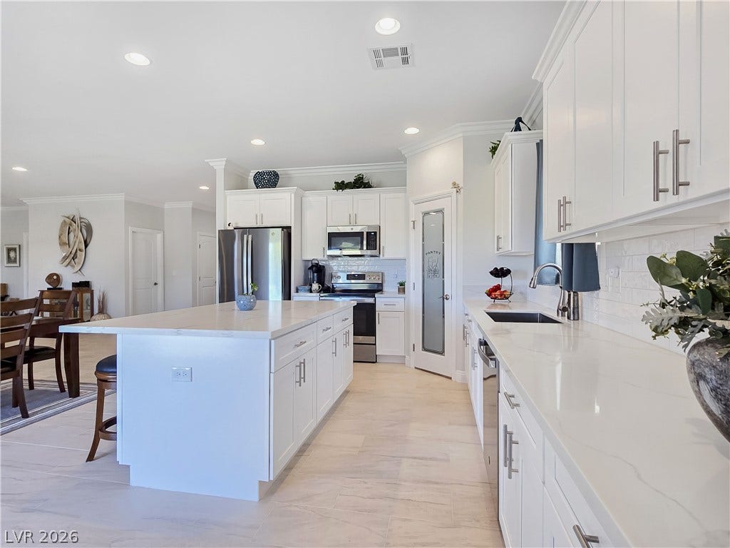 5471 Lincolnwood Court, Pahrump, NV 89061 An open kitchen layout is enhanced by recessed lighting, crown molding, and stone countertops.