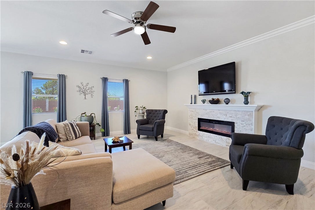 5471 Lincolnwood Court, Pahrump, NV 89061 Crown molding and a modern fireplace elevate this welcoming living space.