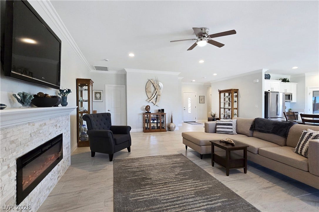 5471 Lincolnwood Court, Pahrump, NV 89061 An open floorplan connects the living area to the kitchen, highlighted by a modern fireplace.