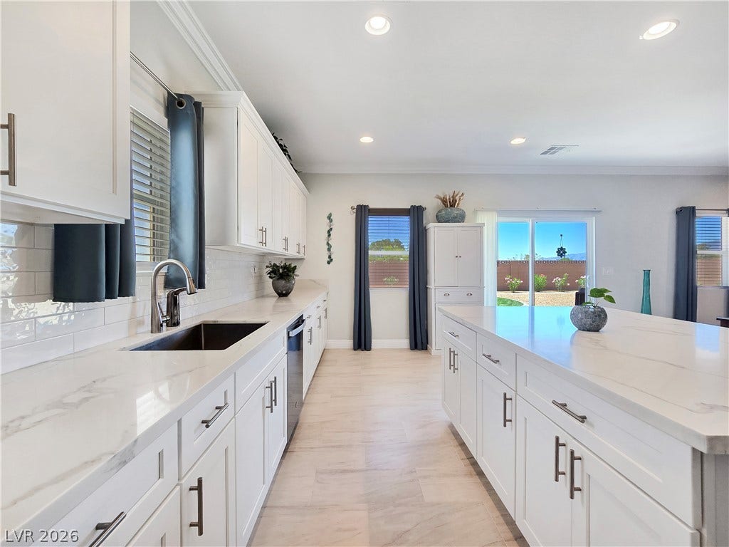 5471 Lincolnwood Court, Pahrump, NV 89061 Gleaming stone countertops and a spacious island anchor this light-filled culinary space.