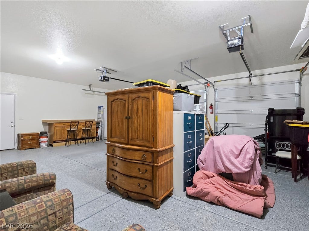 5471 Lincolnwood Court, Pahrump, NV 89061 A spacious multi-vehicle garage features durable concrete flooring and a built-in workbench.