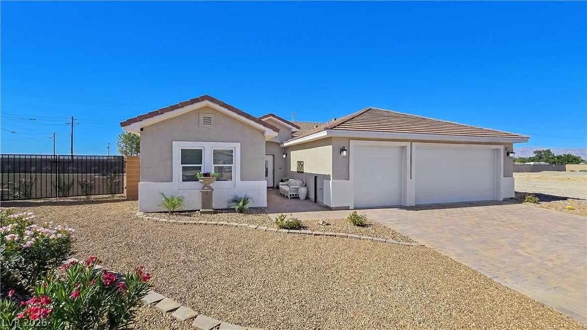 5471 Lincolnwood Court, Pahrump, NV 89061 An inviting stone-paved driveway leads to a modern exterior with pristine desert landscaping.