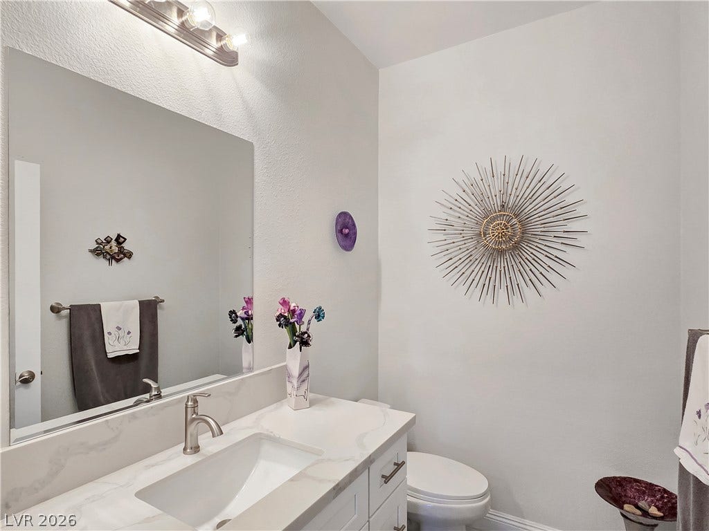 5471 Lincolnwood Court, Pahrump, NV 89061 A classic vanity with stone counters and modern fixtures illuminates this half bathroom.