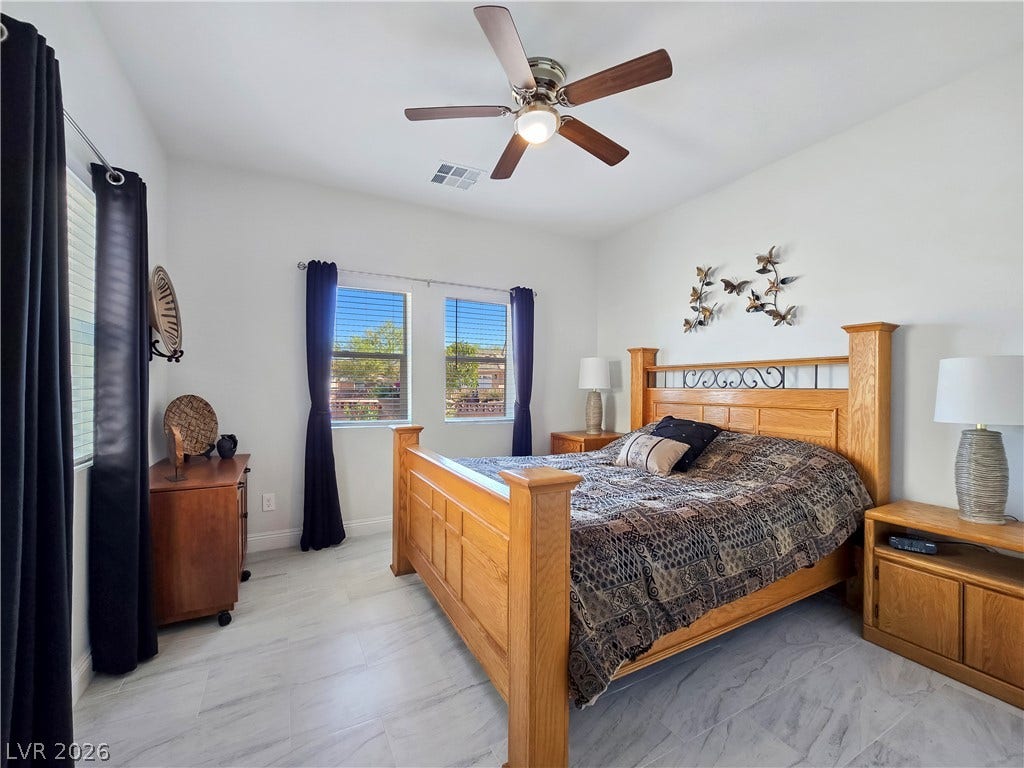 5471 Lincolnwood Court, Pahrump, NV 89061 Clean tile flooring and abundant natural light define this welcoming bedroom space.