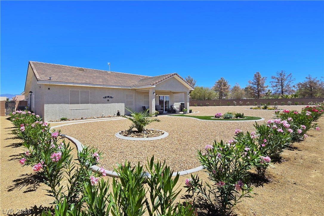 5471 Lincolnwood Court, Pahrump, NV 89061 Manicured desert landscaping frames a covered patio and tile roof on this modern ranch exterior.