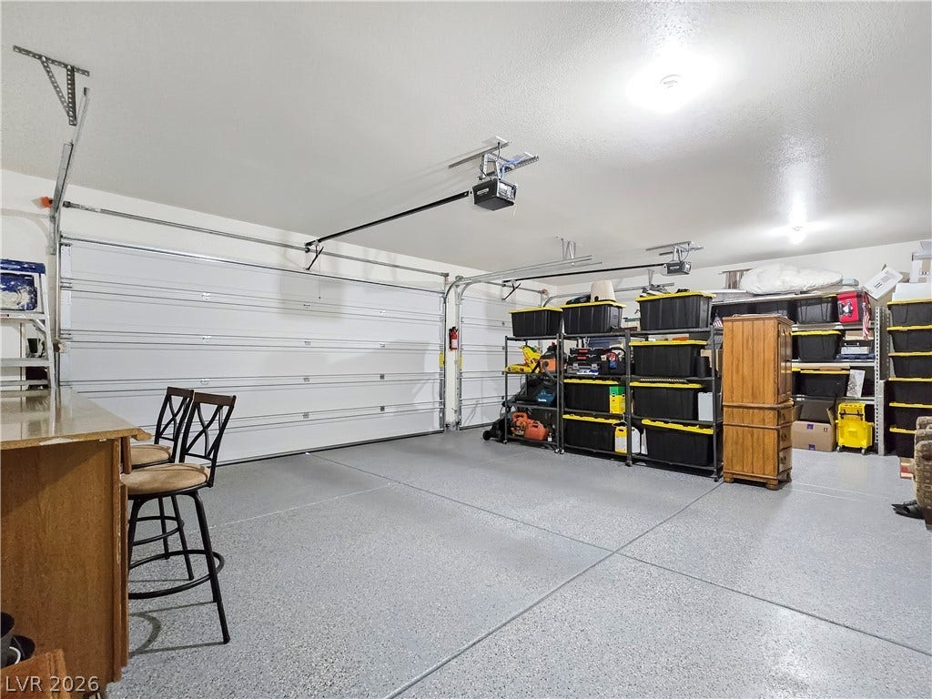 5471 Lincolnwood Court, Pahrump, NV 89061 A spacious garage includes durable epoxy flooring alongside ample integrated shelving options.