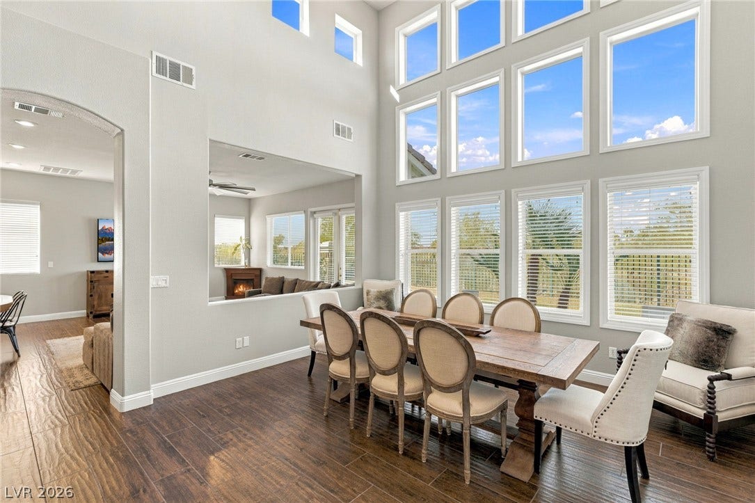 2984 Via Della Amore, Henderson, NV 89052 Double-height ceilings and a dramatic wall of windows highlight this bright dining space.