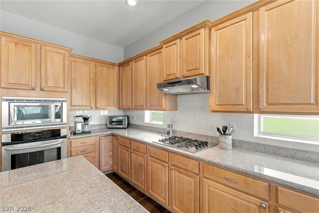 2984 Via Della Amore, Henderson, NV 89052 Ample wooden cabinetry and stone countertops define this well-appointed cooking space.
