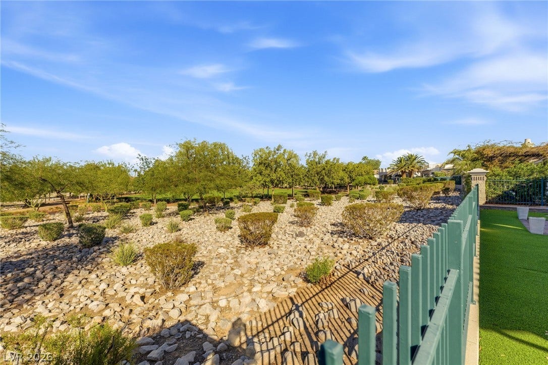 2984 Via Della Amore, Henderson, NV 89052 Mature trees and low-maintenance desert plantings border the perimeter metal fencing.