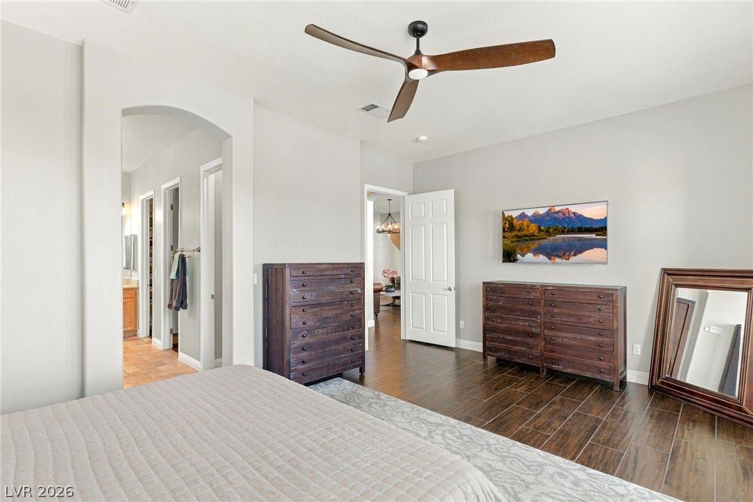 2984 Via Della Amore, Henderson, NV 89052 Gleaming hardwood floors and a wide arched opening define this serene main bedroom suite.