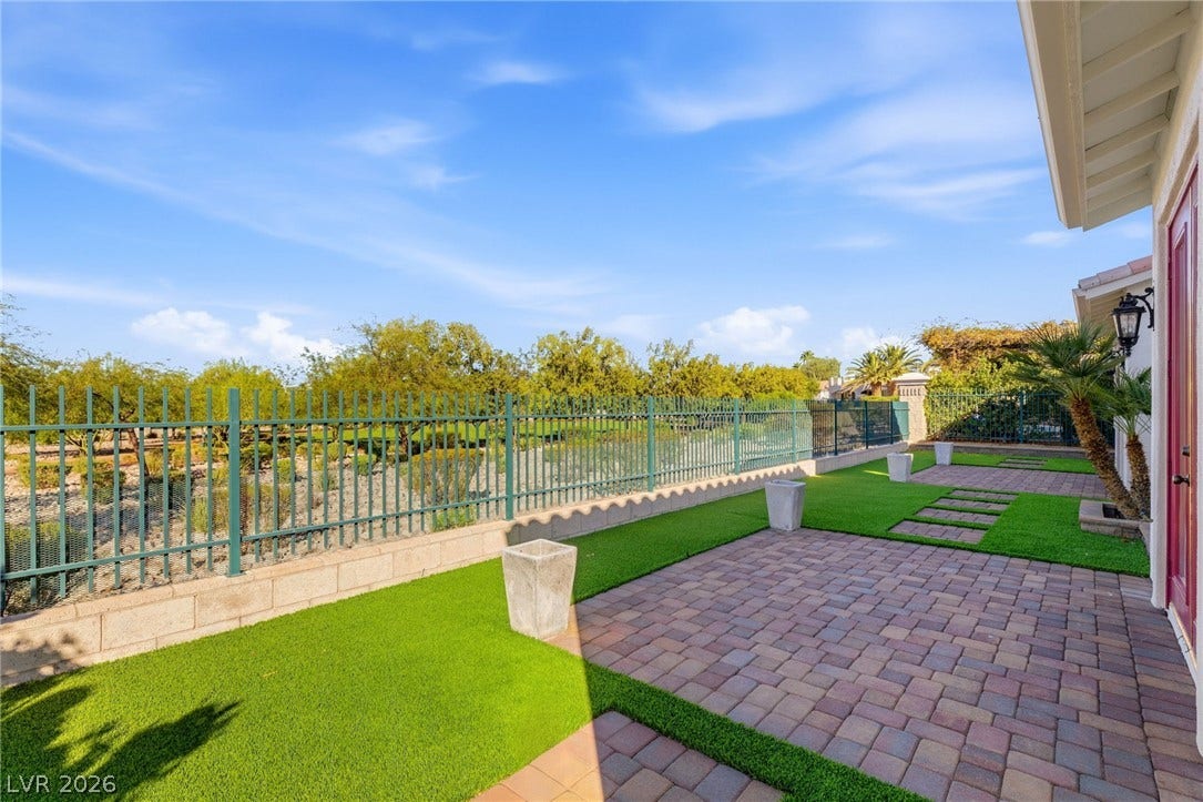 2984 Via Della Amore, Henderson, NV 89052 An inviting paved patio area is bordered by clean fencing and artificial turf.