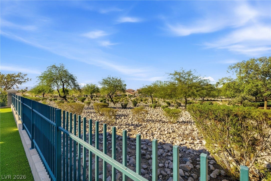 2984 Via Della Amore, Henderson, NV 89052 Mature trees and low-maintenance desert landscaping stretch beyond the property boundary line.