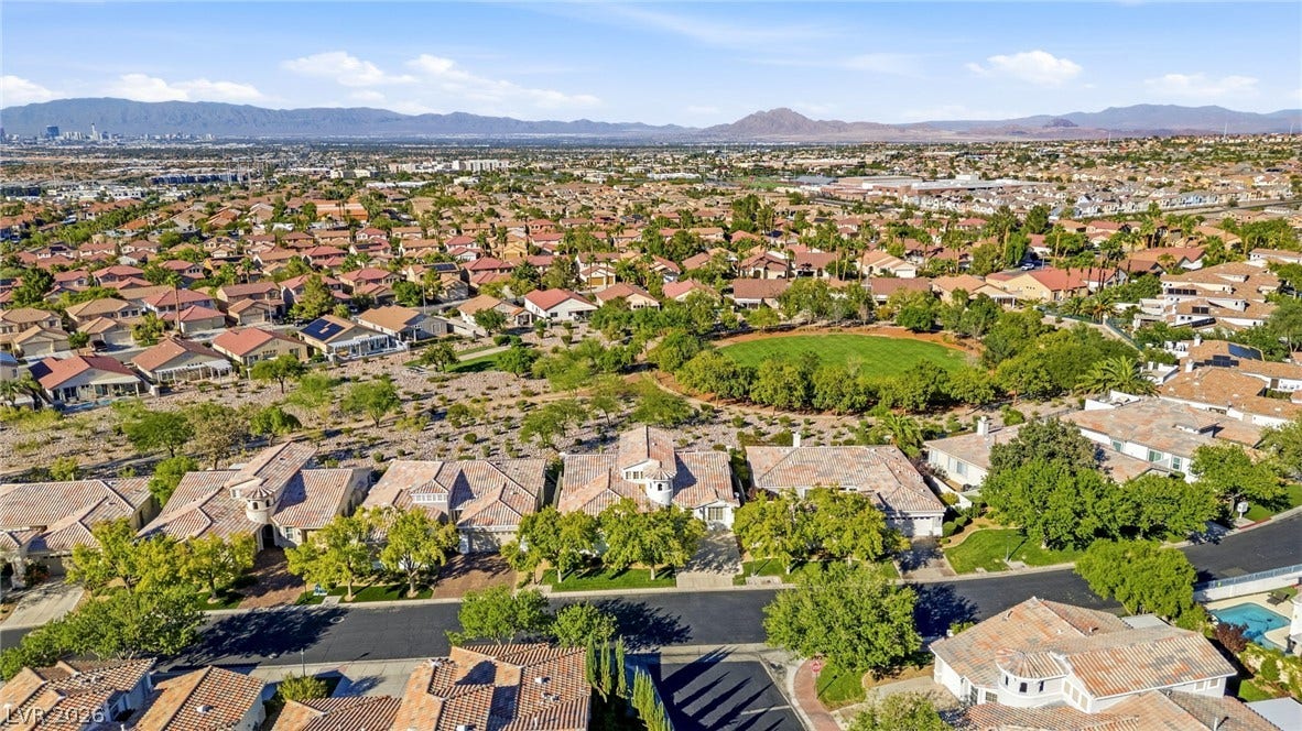 2984 Via Della Amore, Henderson, NV 89052 An aerial perspective showcases a suburban residential enclave nestled near scenic mountain ranges.