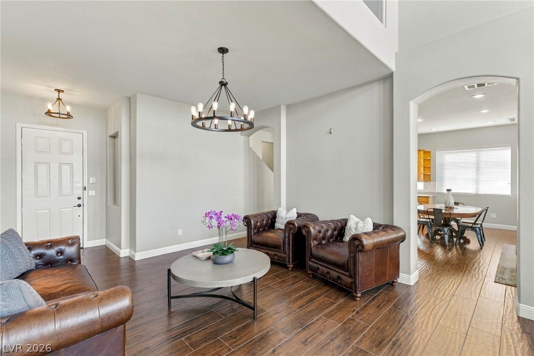2984 Via Della Amore, Henderson, NV 89052 Gleaming hardwood floors and a statement chandelier define this inviting central living space.