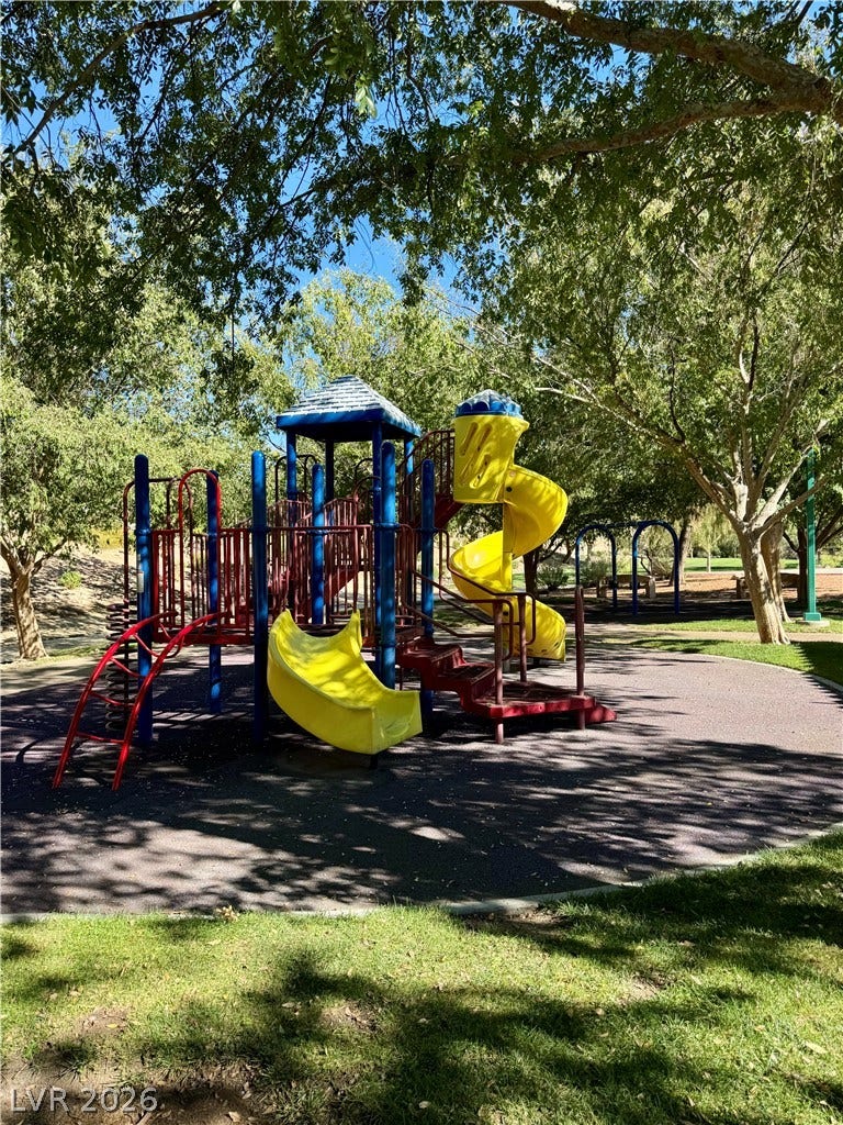 2984 Via Della Amore, Henderson, NV 89052 Mature trees shade a neighborhood park featuring modern play structures and grassy lawns.