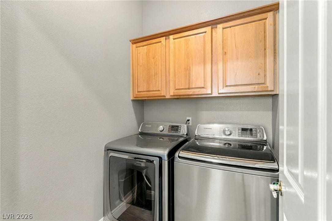 2984 Via Della Amore, Henderson, NV 89052 Functional utility space with built-in overhead cabinetry and modern laundry appliances.