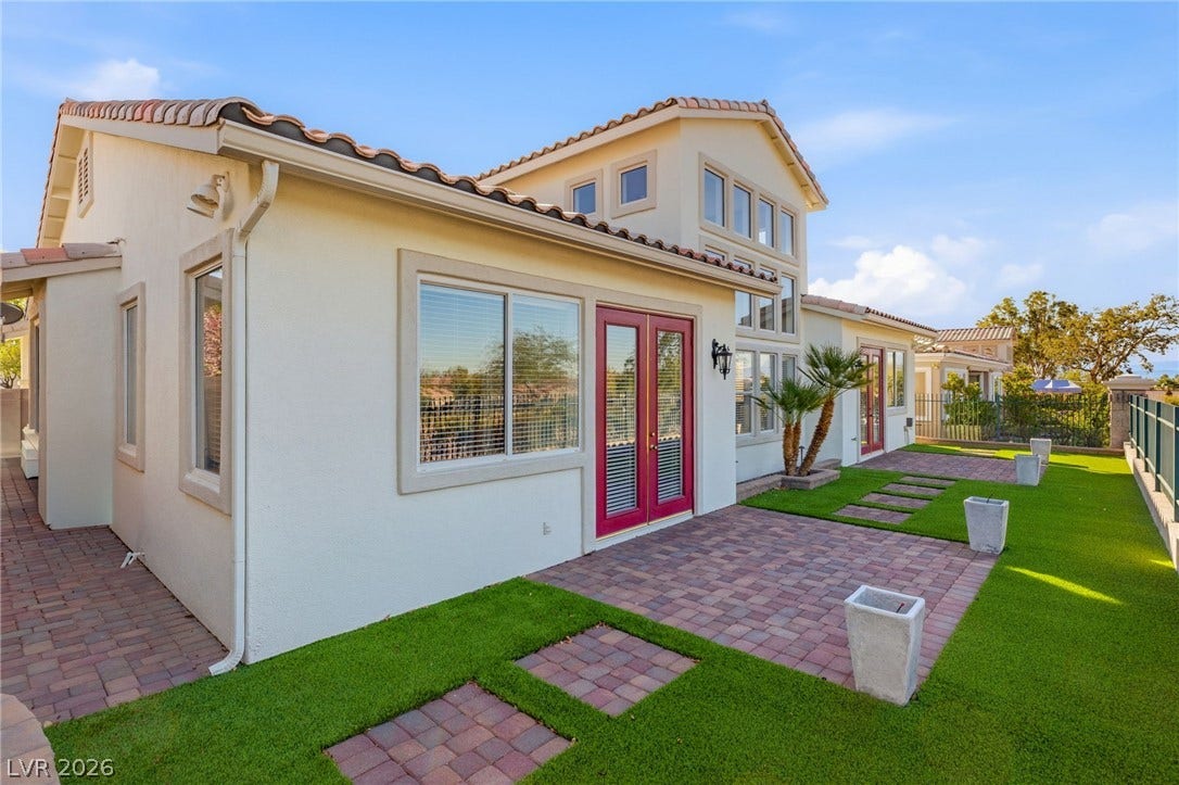 2984 Via Della Amore, Henderson, NV 89052 A paved patio and tidy lawn area extend along the rear of this stucco home.