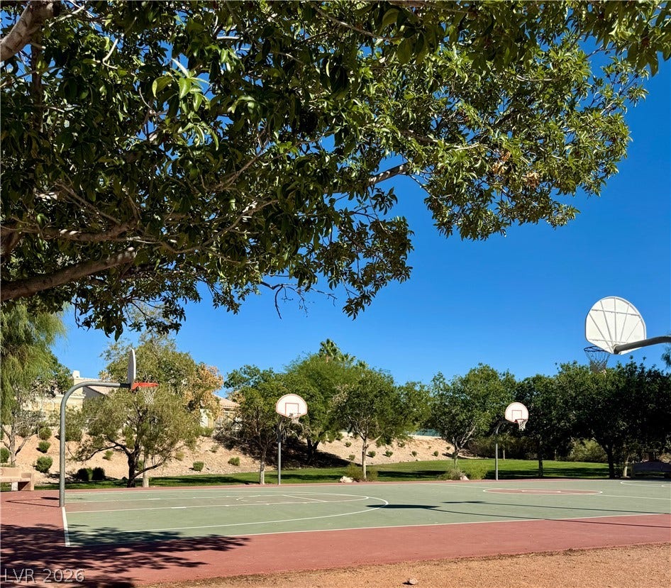 2984 Via Della Amore, Henderson, NV 89052 Lush trees shade a multi-hoop outdoor basketball court set against a clear blue sky.