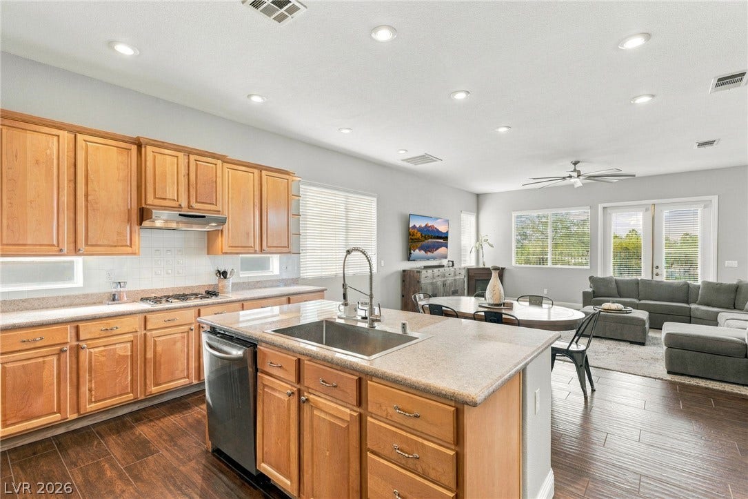 2984 Via Della Amore, Henderson, NV 89052 Warm wood cabinetry and an expansive central island highlight this inviting open-concept kitchen.