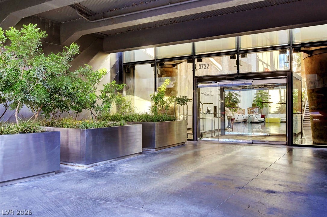 3722 Las Vegas Boulevard, #303, Las Vegas, NV 89158 A modern covered entrance features soaring glass walls and sleek concrete flooring.