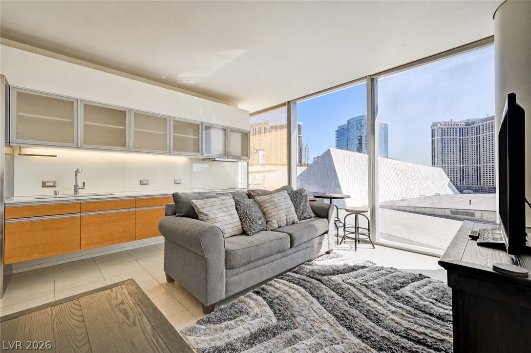 3722 Las Vegas Boulevard, #303, Las Vegas, NV 89158 Floor-to-ceiling windows frame a dynamic urban view in this open-concept living space.