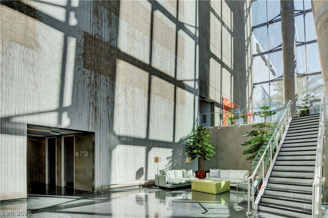 3722 Las Vegas Boulevard, #303, Las Vegas, NV 89158 Dramatic light filters through a multi-story glass wall onto polished stone floors.