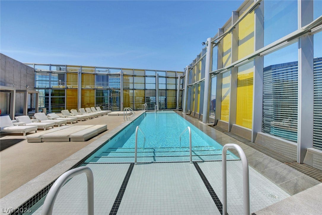 3722 Las Vegas Boulevard, #303, Las Vegas, NV 89158 An outdoor lap pool rests under open skies, flanked by sleek modern glass windbreaks.