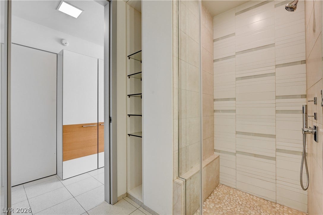 3722 Las Vegas Boulevard, #303, Las Vegas, NV 89158 A glass-enclosed shower showcases textured wall tiling, a pebble floor, and integrated bench seating.