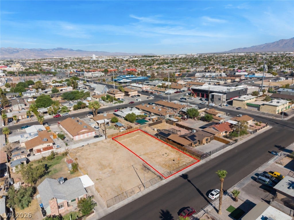 2321 McCarran Street, North Las Vegas, NV 89030 An aerial perspective shows a vacant residential lot bordered by paved neighborhood streets.
