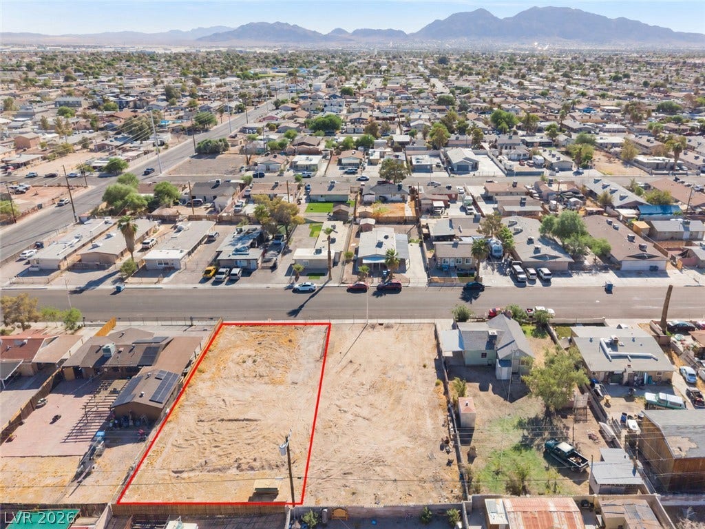2321 McCarran Street, North Las Vegas, NV 89030 An aerial perspective showcases a vacant residential lot set against a majestic mountain backdrop.