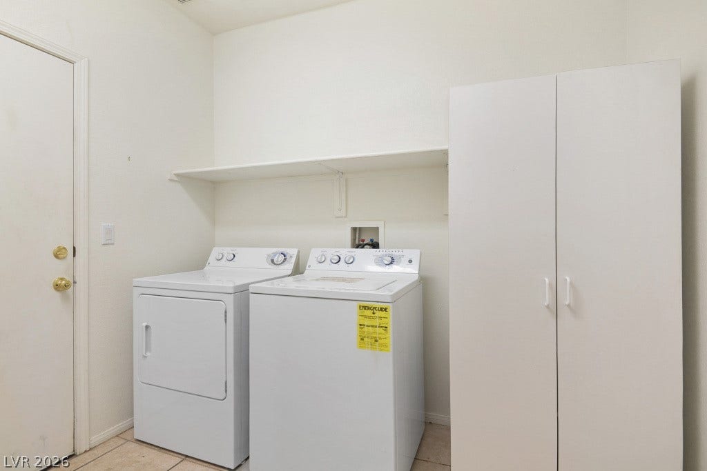 6729 Quarterhorse Lane, Las Vegas, NV 89148 Dedicated laundry room featuring washer and dryer, built-in upper shelving, freestanding storage cabinet, neutral tile flooring, and direct garage access.