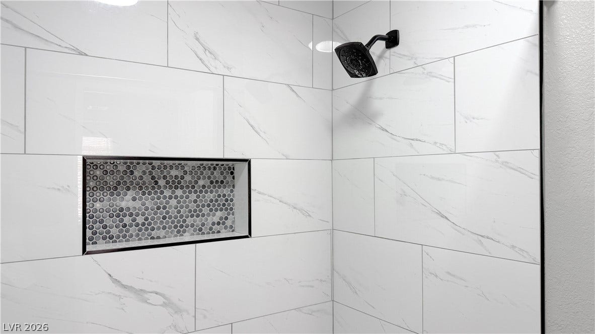 4321 Gannet Circle, #199, Las Vegas, NV 89103 Elegant marble-patterned wall tiles and a built-in mosaic niche elevate this modern shower.