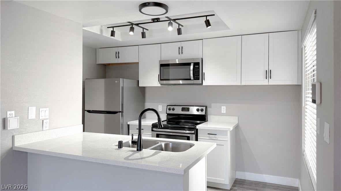 4321 Gannet Circle, #199, Las Vegas, NV 89103 Streamlined cabinetry and quartz countertops define this modern, light-filled kitchen space.