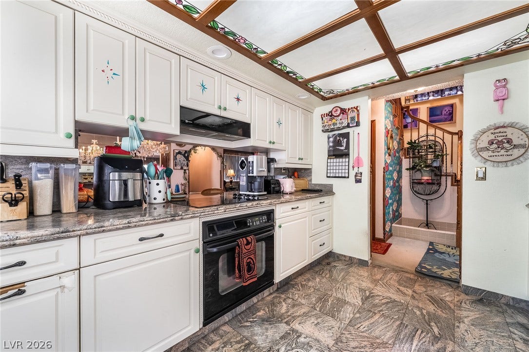 Granite counters and unique wood-trimmed ceiling details define this well-appointed cooking space.